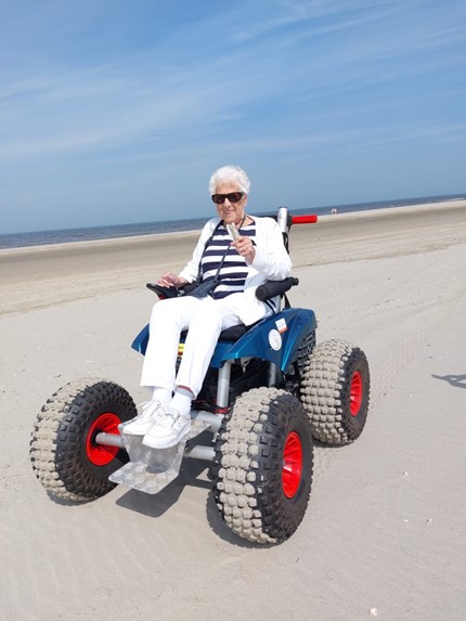 elektrische rolstoel op het strand avavieren.